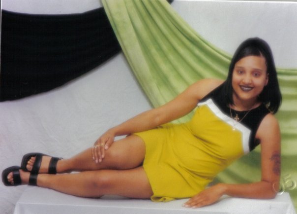 A woman laying down, wearing a yellow dress